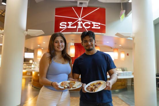 Two students showing the camera their plates of food