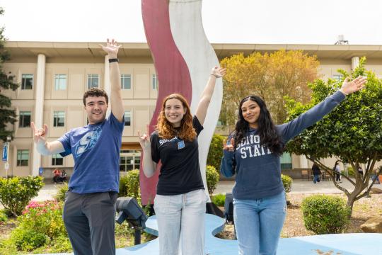 Group poses in front of the 'Bacon and Eggs' sculpture