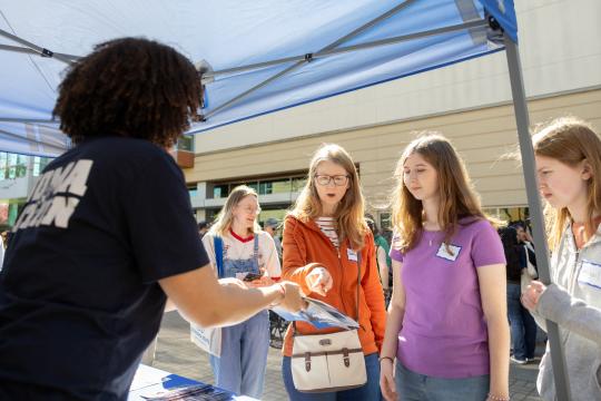 Flier being shown to a family by SSU representative at a table