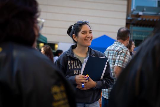 Student smiles in a crowd of people
