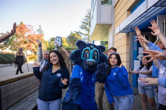 Lobo mascot poses with a group of students