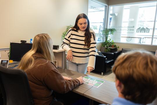 Student pointing to housing map in the REACH office