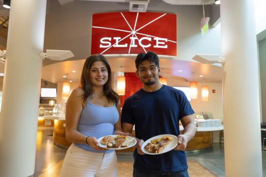 Two students showing the camera their plates of food