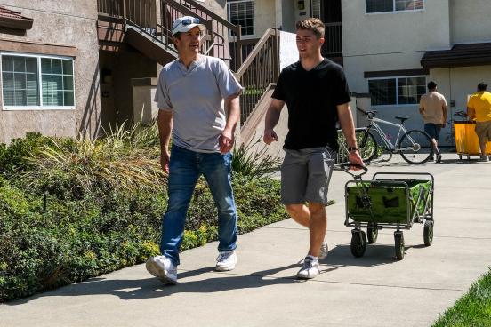 Parent and student with a wagon walking to move in