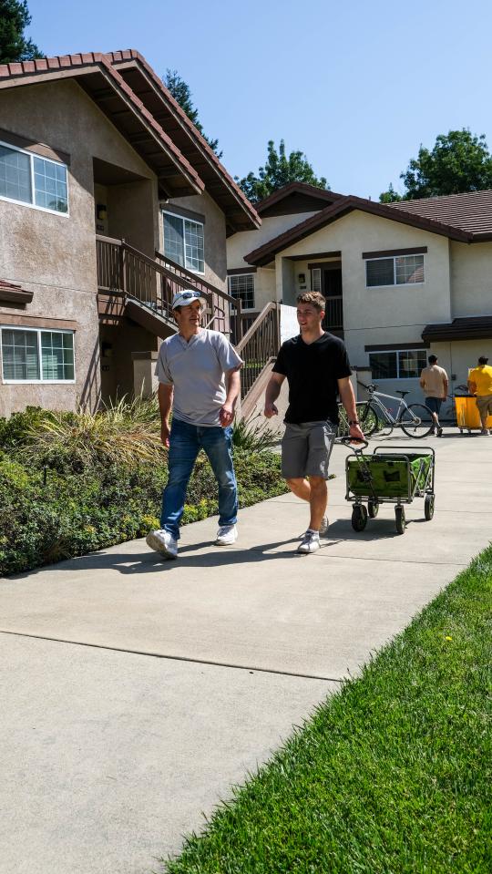 Parent and student with a wagon walking to move in