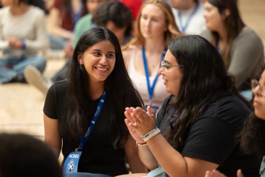two girls talking and sitting on ground