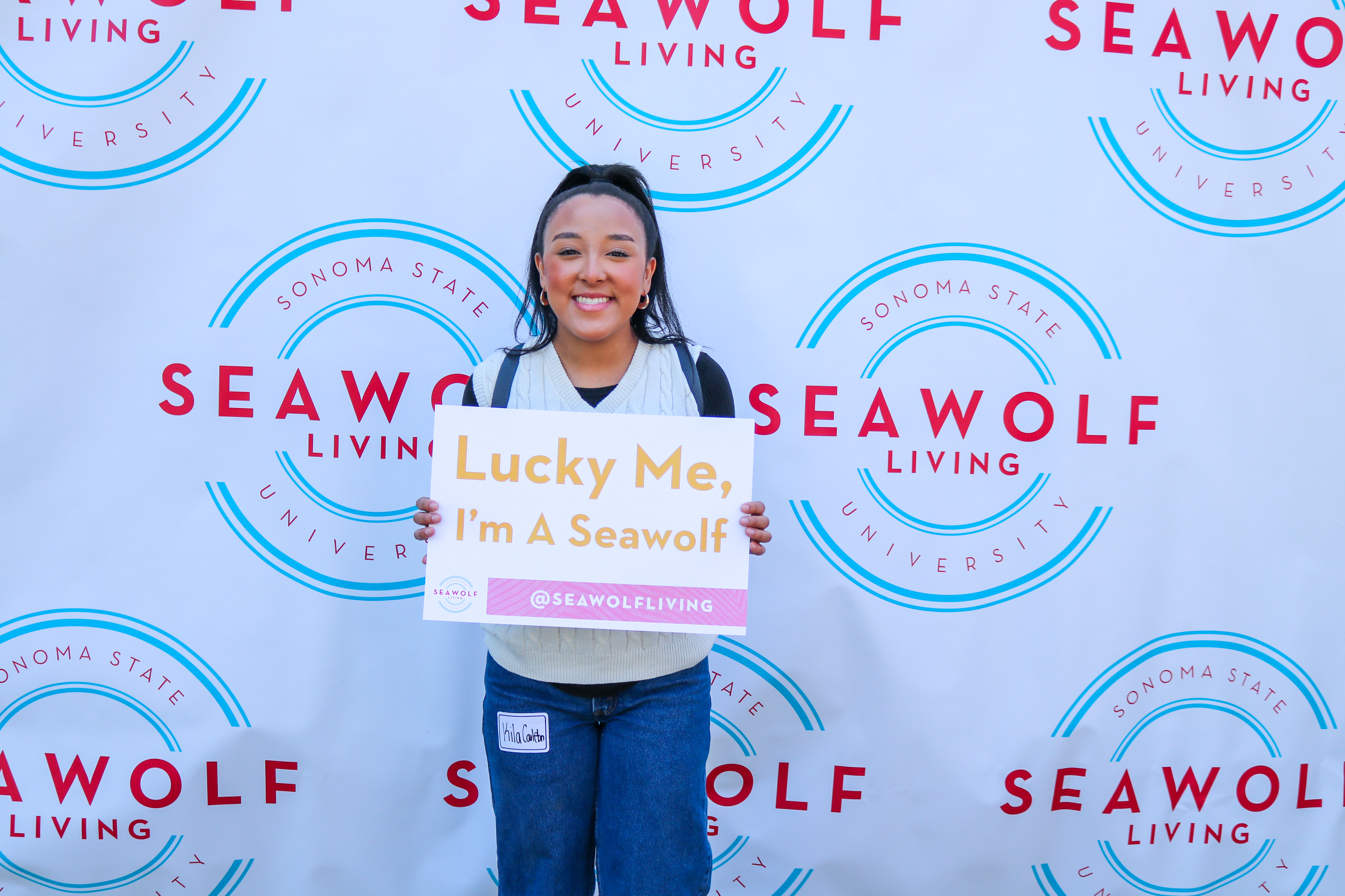 Person holding a sign that says lucky me I'm a seawolf